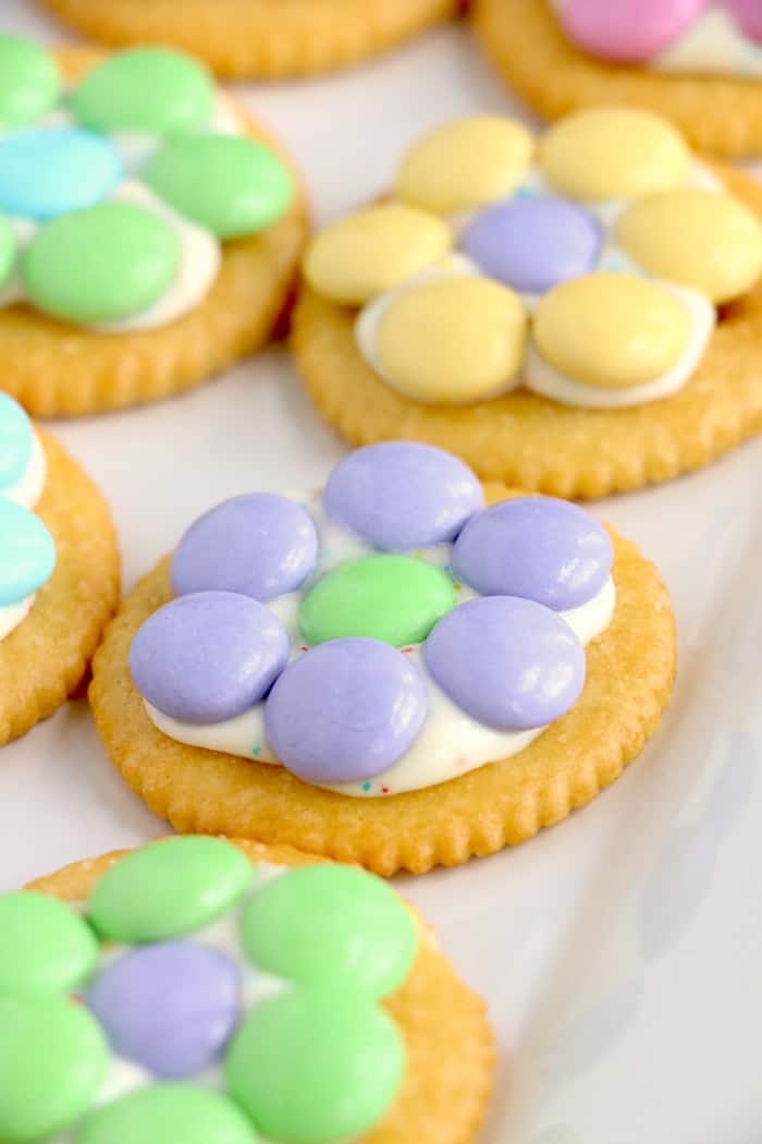 Spring Flower Ritz Cracker Recipe - Crispy Ritz Crackers covered with melted confetti white chocolate chips, and finally topped off with a gorgeous M&M flower. #inspirationalmomma #springtreats #springdesserts #eastertreats #easterdesserts #ritzcracker #m&ms #easydessert #quick #recipe #ritzcrackerrecipes