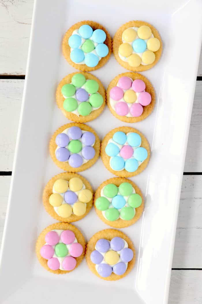 Spring Flower Ritz Cracker Recipe - Crispy Ritz Crackers covered with melted confetti white chocolate chips, and finally topped off with a gorgeous M&M flower. #inspirationalmomma #springtreats #springdesserts #eastertreats #easterdesserts #ritzcracker #m&ms #easydessert #quick #recipe #ritzcrackerrecipes