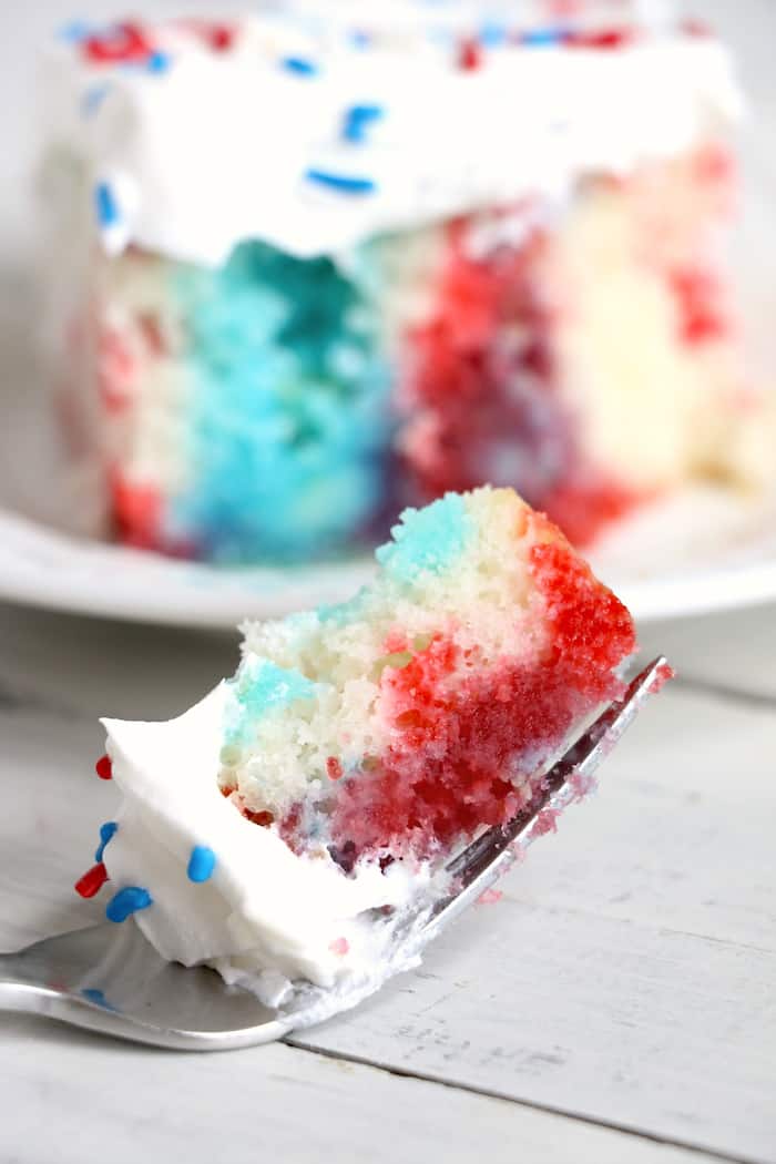 Show your American pride with this Patriotic Jello Poke Cake! Moist, delicious cake drizzled with sweet, colorful jello, all covered with whipped topping! #InspirationalMomma #jellopokecake #pokecake #America #4thofJuly #jello #cake #dessert #desserts #recipe #patriotic #redwhiteblue