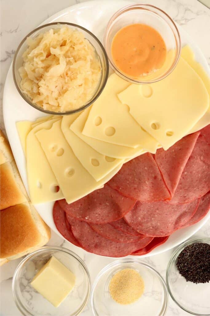 Overhead shot of individual corned beef sliders ingredients on plate on table