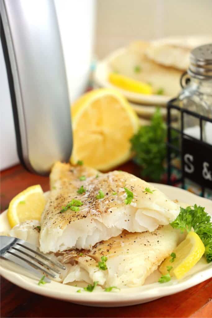 Two halves of air fryer cod on plate.