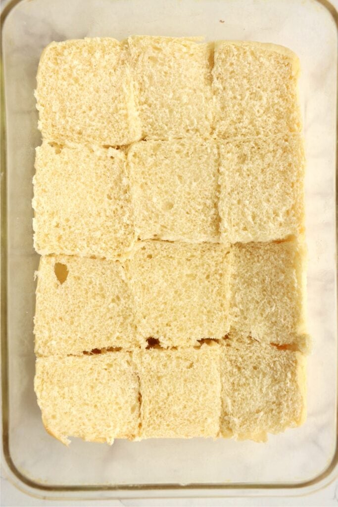 Overhead shot of bottom halves of Hawaiian rolls in baking dish. 