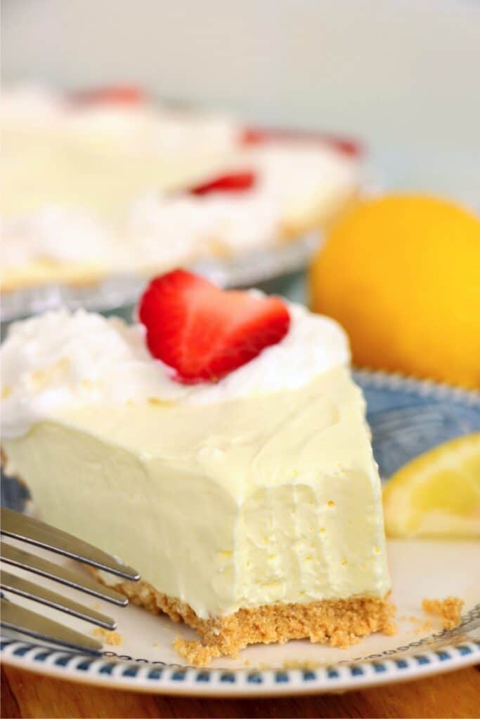 Closeup shot of slice of lemon cream cheese pie with bite removed.